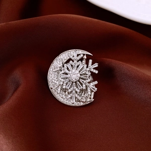 Macro shot of silver crescent moon and snowflake brooch with sparkling cubic zirconia