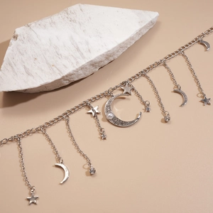 Détail du collier argenté étoile et lune avec strass brillants et incrustation de perle