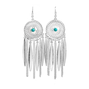 Macro detail of ethnic silver tassel earrings with blue turquoise stones on white background