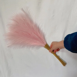 Close-up of fluffy pink faux pampas grass plumes with brown stems for boho home decor