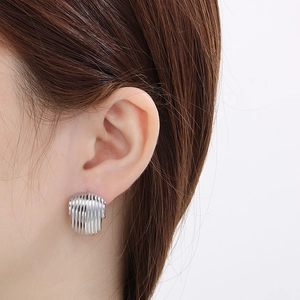 Close-up of silver textured vertical ribbed hollow semi-circle stainless steel earrings
