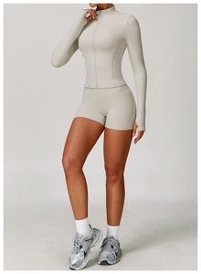 Macro detail of breathable white yoga jacket with thumb holes and premium zipper design