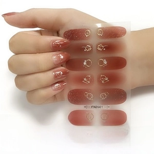 Detail showing aurora water transfer nail art stickers with gold star and moon patterns