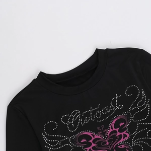 Dettaglio di una t-shirt nera a girocollo con stampa di farfalla rosa e lettere in strass argento