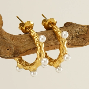 Boucles d'oreilles créoles dorées texture lave et perles sur branche naturelle