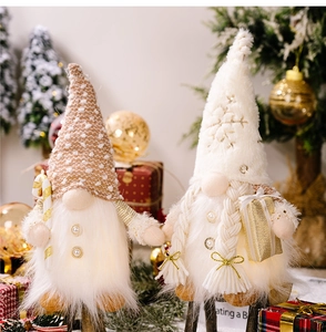 Close-up of lighted Christmas plush gnomes with long beards and holiday decorations