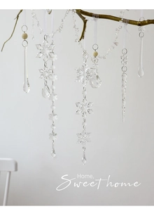 Detalle de copos de nieve y carámbanos de acrílico en ramas para decoración navideña