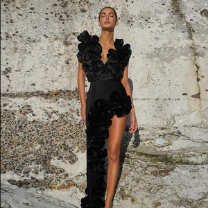 Detailed view of the dramatic ruffled neckline and satin texture on this black dress
