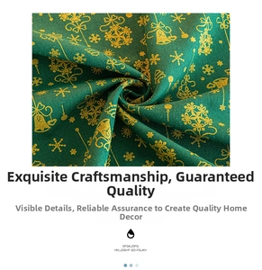 Close-up of green Christmas tablecloth fabric with gold snowflake and bell printing