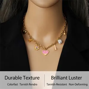 Detail of gold chain necklace with colorful enamel charms, pearl and Amour pendant