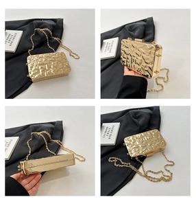 Detail of gold metallic clutch bag featuring hammer texture and detachable chain strap