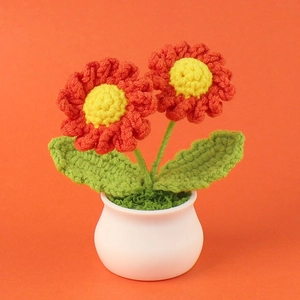 Handmade crochet red daisy flower in a white ceramic pot for home and desk decoration