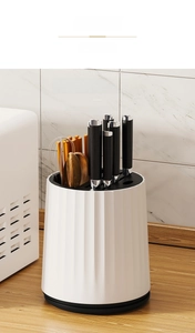Detail showing multi-slot white rotating kitchen knife block with vertical wave texture
