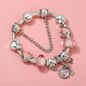 Detailed close-up of a silver charm bracelet with pink glass beads and animal pendants