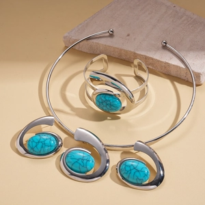 Detailed shot of bohemian resin turquoise necklace and open bangle on stone props