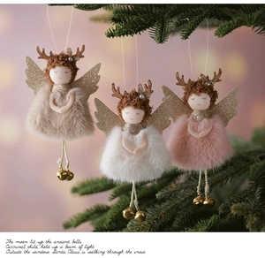 Three plush Christmas angel ornaments with reindeer antlers and bells hanging on a tree
