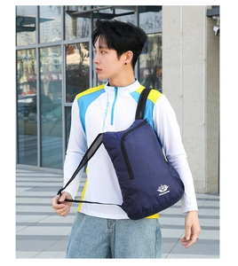 Outdoor view of a navy foldable sports chest bag worn by a model in a urban scene