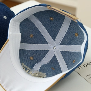 Dettaglio interno del cappellino in denim per neonati con fascia bianca e bordo in camoscio