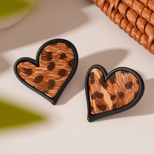 Détail de boucles d'oreilles en cœur à motif léopard avec bordure noire mate rétro