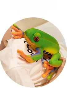 Detail of green plush frog toy featuring vibrant red eyes and soft realistic textures