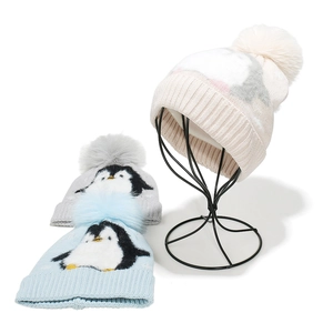 Cute kids penguin knit beanie with pom-pom in white, blue and grey winter colors