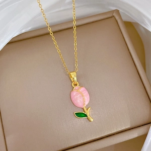 Detailed close-up of pink tulip necklace pendant with gold chain on silk