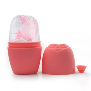 Pink silicone ice roller for face with rose pattern and transparent ice showing petals