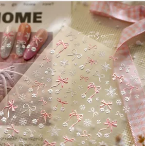 5D embossed nail art stickers featuring pink and white bows with winter snowflake patterns