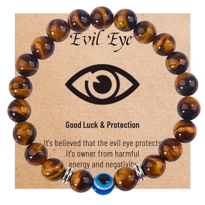 Elastic Evil Eye bracelet featuring blue eye bead and matte tiger eye stones on card