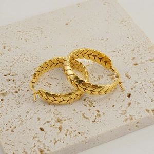 Boucles d'oreilles créoles dorées 18K à texture épi sur un socle en pierre beige