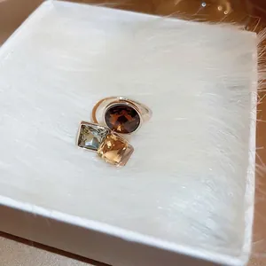 Gold-plated open ring with multicolored cubic zirconia crystals in a white jewelry box