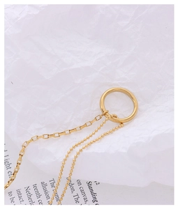 Detailed close-up of 18k gold plated ring pendant and mixed chain textures