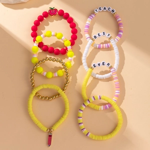 Detail of colorful beaded bracelets with apple charms and teacher theme letter beads