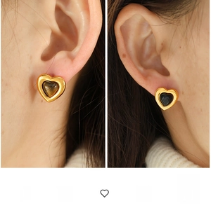 Macro shot of French vintage heart earrings with tiger eye and black stones in gold settings