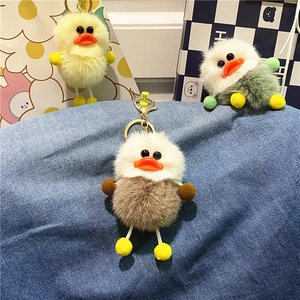 Close-up of cute plush duck keychains in various colors with golden alloy metal clasps