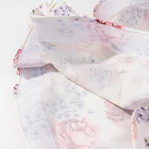 Vue détaillée du tissu en maille blanche avec imprimé floral et doublure superposée