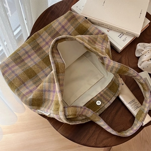 Gros plan du sac cabas en laine à carreaux avec boucle magnétique et poche interne