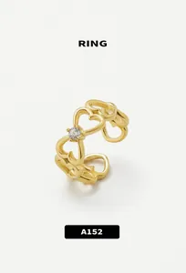 Macro detail of gold-plated heart ring with sparkling crystal and adjustable band