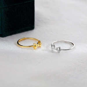 Elegant bow-shaped sterling silver rings in gold and silver finish with spiral texture