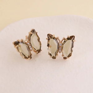 Macro detail of butterfly earrings with olive green gems and gold plating on S925 needles