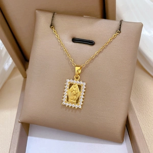 Macro view of gold rectangle necklace pendant with cubic zirconia and saint portrait