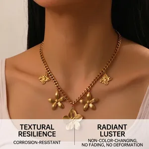 Detailed view of a gold flower pendant necklace on model with chunky Cuban chain links