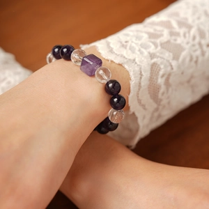 Détail d'un bracelet en améthyste et cristal blanc porté au poignet avec dentelle
