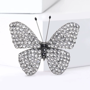 Detailed view of silver butterfly brooch with clear rhinestones and black gemstone accents