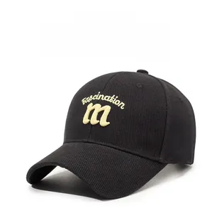 Close-up of black baseball cap featuring fascination embroidery and corduroy texture