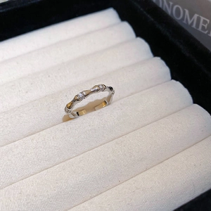 Detail of silver bamboo style ring with cubic zirconia stones on white fabric