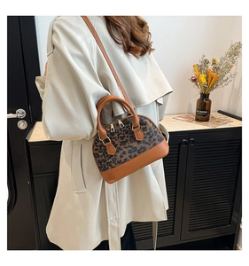 Brown PU leather and leopard print shell bag shown on a model wearing a trench coat