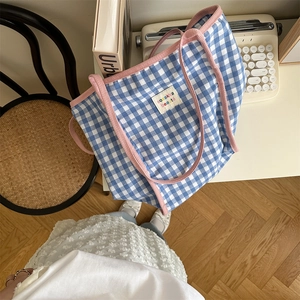 Detail view of blue and pink checkered canvas tote bag with thick pink rope handles