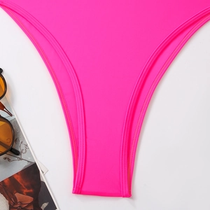 Close-up of neon pink swimsuit bottom featuring reinforced stitching and high-stretch fabric