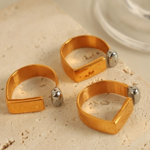 Three minimalist two-tone open rings with textured gold bands and silver bead accents
